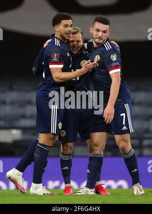 Scotland's Che Adams (left) celebrates scoring their side's third goal of the game with team-mates Ryan Fraser and John McGinn (right) during the 2022 FIFA World Cup Qualifying match at Hampden Park, Glasgow. Picture date: Wednesday March 31, 2021. Stock Photo