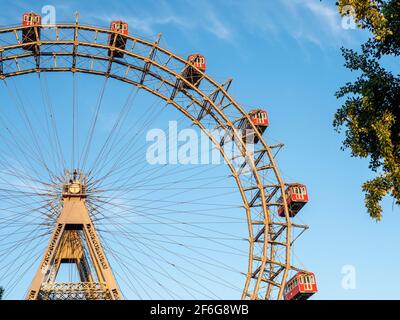 The Prater Ferris Wheel: Riesenrad Wurstelprater: Vienna's famous amusment park's most famous attraction a huge antique ferris wheel at sunset in a cloudless day. Stock Photo