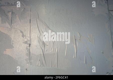 uneven paper glued on wall with air pockets painted grey Stock Photo