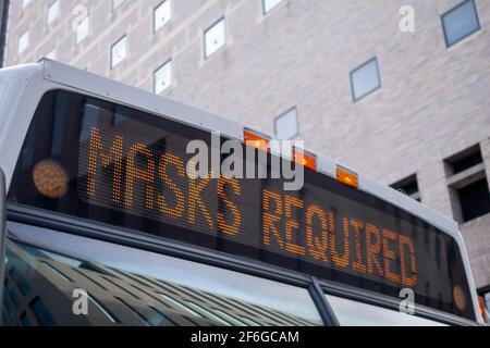 lighted message on the header of city bus reading Masks Required covid 19 Stock Photo