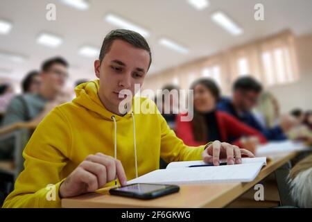 a portrait of a concentrated Student using a calculator while calculating in a math class Stock Photo