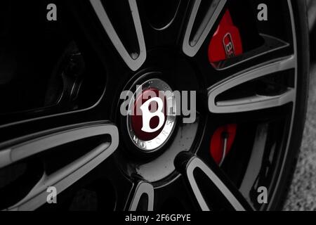 The Front Wheel Bentley Badge On The Front Wheel With Red Brake Calliper Of A 2016 Bentley Continental Flying Spur Stock Photo