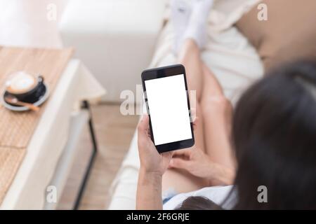 Close up hands of woman using mobile phone, cell phone in coffee shop. Hands of women holding blank empty screen smart phone in cafe. Women relax with Stock Photo