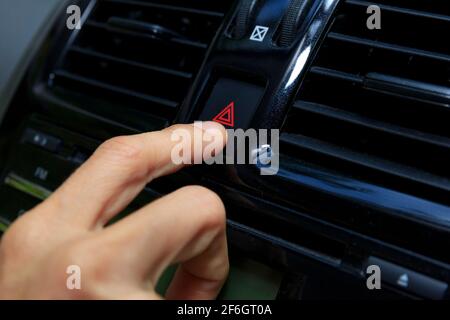 Close up hand press the emergency light in the car, Fingers press button.for open the contract emergency light in car. Emergency button press for open Stock Photo