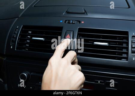 Close up hand press the emergency light in the car, Fingers press button.for open the contract emergency light in car. Emergency button press for open Stock Photo