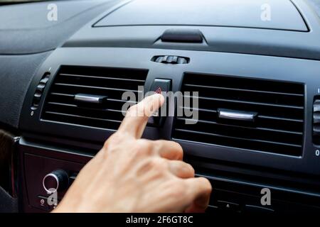 Close up hand press the emergency light in the car, Fingers press button.for open the contract emergency light in car. Emergency button press for open Stock Photo