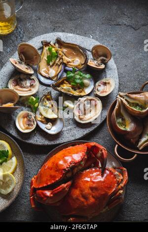 Fresh seafood shellfish mussels, clams, crabs and snails on gray background