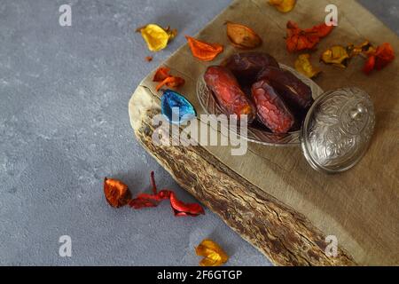 Dried dates on a wooden table in silver dishes close-up. Composition of dried dates in ramadan dish on wooden table. Stock Photo