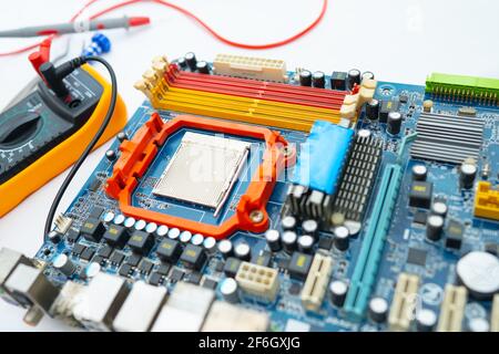 Multimeter with main board, maintenance, repairing and checking computer hardware concept. Stock Photo