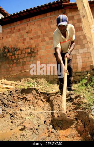 guaratinga, bahia, brazil - may 7, 2009: worker uses hoe to dig in land in the rural area of the city of Guaratinga, in southern Bahia. Stock Photo