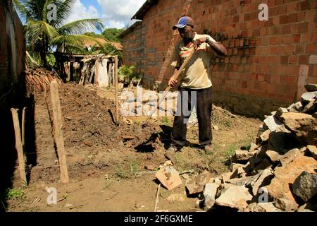 guaratinga, bahia, brazil - may 7, 2009: worker uses hoe to dig in land in the rural area of the city of Guaratinga, in southern Bahia. Stock Photo