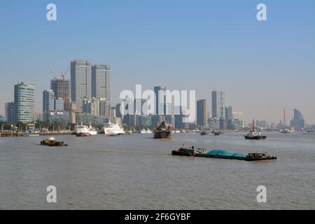 Large variety of shipping on the Huangpu river in Shanghai. Barges carry cargo and tour boats bring tourists in to the city. Stock Photo