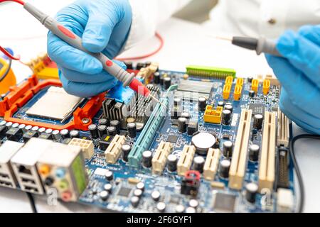 Technician repairing micro circuit main board computer electronic technology, hardware, mobile phone, upgrade, cleaning concept. Stock Photo