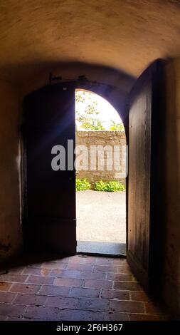 Door gate antique portal open sun shines in, view of the park garden, gate to the monastery church old building, historical architecture, wildly roman Stock Photo