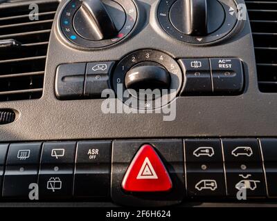Plastic car control panel with buttons and knobs. Car air conditioner adjustment. Air flow in the vehicle interior. Vehicle alarm. Red alarm button. C Stock Photo