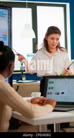 Executive director woman briefing collegues, explaning company strategy during brainstorming. Multiethnical businesspeople working in professional startup financial office during conference meeting Stock Photo