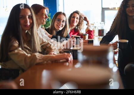 Cheerful female colleagues drinking coffee in office Stock Photo