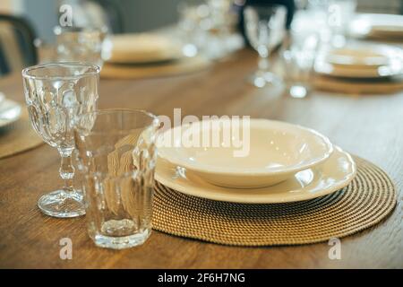 Wooden table with empty plates and glasses. Dinner table setting Stock Photo