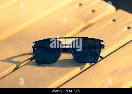 Oversized sunglasses model with big black lenses shoot outside in nature in a summer day closeup . Selective focus Stock Photo