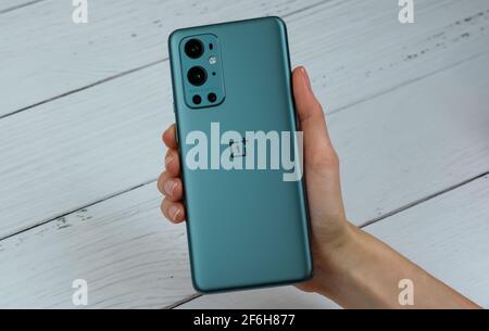 OnePlus 9 Pro 5G in Pine Green color. Stock Photo