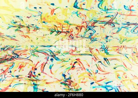 Abstract pastel creme color paint strokes like from finger painting on canvas, which is divided into half Stock Photo