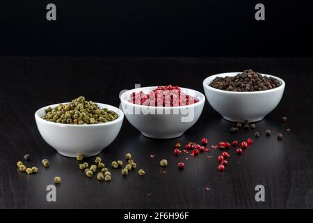 Peppercorns ,green, pink and black peppercorns on a black background Stock Photo