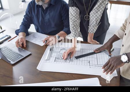 Close-up of architects working in team at the table they drawing blueprints and developing new project of the building Stock Photo