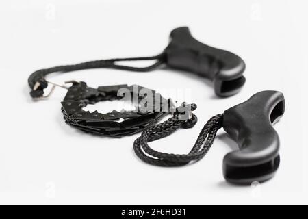 Black portable hand chain saw on white background. Black and white composition. Tool for cutting wood and pruning branches. Saw for garden, hiking and Stock Photo