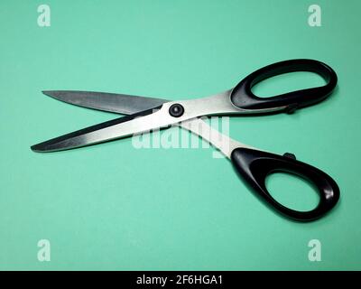 tailor scissors for cutting fabric on a green background Stock Photo
