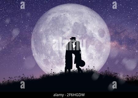 Silhouette at night landscape of couple or lover dancing and singing on the mountain with Milky way background over the full moon. Stock Photo