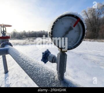 Oil pressure gauge shows 0 ATM (Max 15 Bar - red line). Oil pumpjack winter work. A pumpjack is the overground drive for a reciprocating piston pump i Stock Photo