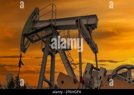 Silhouette of oil pump from oil field. Russia Green Oil pump oil rig energy industrial machine for petroleum crude. oil crisis. Pumps oil pollution. F Stock Photo