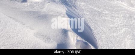 Copyspace template background of dunes and mountains of snowflakes. Panorama Texture of snow waves in bright sunlight. With a natural surface. Winter Stock Photo
