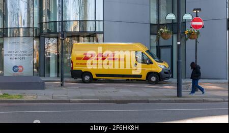 A DHL parcel delivery vehicle making a delivery to a block of offices. Stock Photo