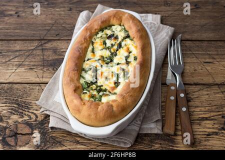 Open cheese pie with chard in Adjara style on the wooden table, top view. Delicious homemade food Stock Photo