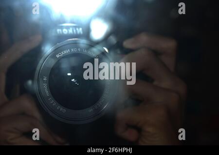 photo of a Nikon DSLR lens with the flash on creating glare. Stock Photo