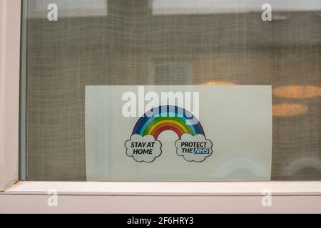 A showing a rainbow is displayed in a house window in support of the NHS during the Covid 19 pandemic.  Petersfield, Cambridge, UK. Stock Photo