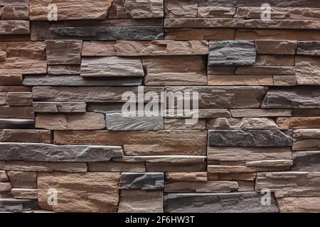 The wall is made of multi-layered natural stone. Stone for building a house. Texture. Close-up Stock Photo