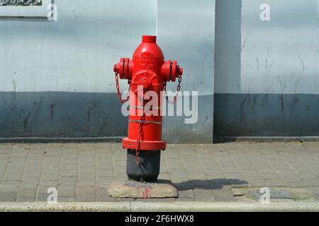 Bright red fire hydrant on a pavement in Shanghai, China. Stock Photo