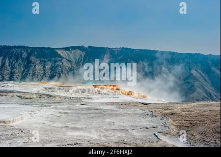 Hot spring at Yellowstone. Rising hot water releases heat energy by evaporation. The microorganisms which live in and around the hot springs often mak Stock Photo