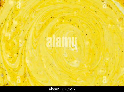 Yellow background of liquid marble sprinkled with sparkles. Stock Photo