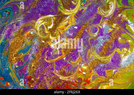 Multicolored acrylic background with curls sprinkled with purple and gold sparkles. Contemporary creativity. A colorful avant-garde painting with rich Stock Photo