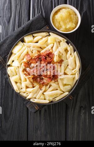 Alpine macaroni alplermagronen is Swiss mac and cheese with potatoes closeup in the plate on the table. Vertical top view from above Stock Photo