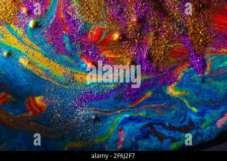Multicolored acrylic background with curls sprinkled with purple and gold sparkles. Contemporary creativity. A colorful avant-garde painting with rich Stock Photo