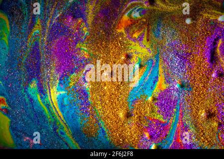 Multicolored acrylic background with curls sprinkled with purple and gold sparkles. Contemporary creativity. A colorful avant-garde painting with rich Stock Photo