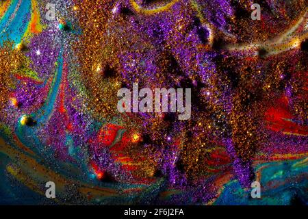 Multicolored acrylic background with curls sprinkled with purple and gold sparkles. Contemporary creativity. A colorful avant-garde painting with rich Stock Photo