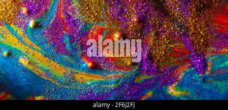 Multicolored acrylic background with curls sprinkled with purple and gold sparkles. Contemporary creativity. A colorful avant-garde painting with rich Stock Photo
