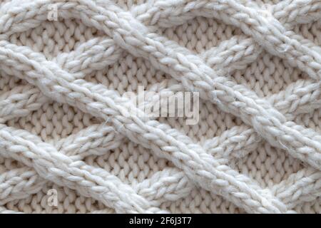 Background from beautiful, knitted background, Aran pattern, weave from braids. Concept handicrafts, DIY, leisure, fashionable warm clothes, hobbies. Stock Photo