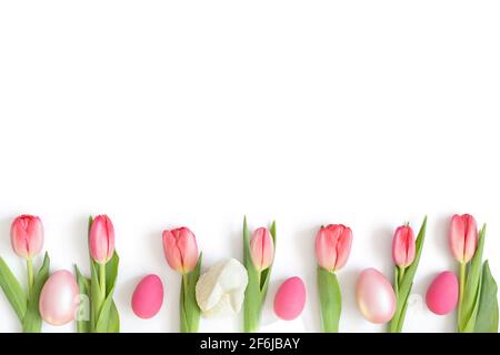 Easter composition with pink tulips, eggs and an Easter bunny isolated on a white background. Space for text. Top view, flat lay. Stock Photo