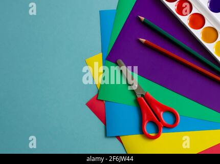 colored paper, cardboard, paints, scissors, pencils for creativity and crafts with children. on a blue background.stationery, space for the text. soft Stock Photo